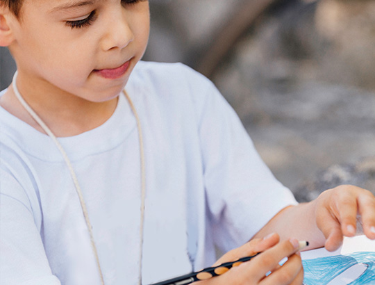 Young boy coloring a fish