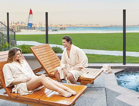 Couple relaxing by outdoor hot tub overlooking Mission Bay