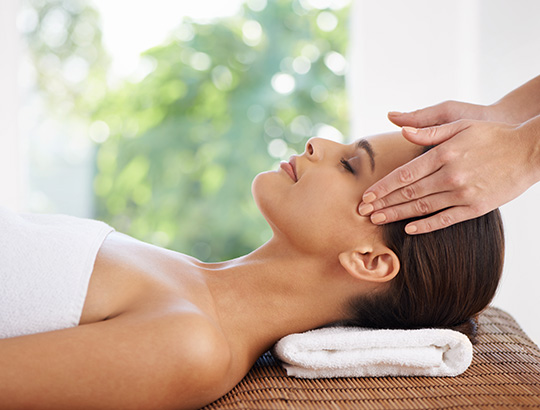 Woman relaxing while getting a head massage