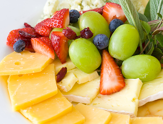 Close up of fruit and assorted cheeses