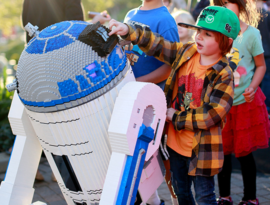 At LEGOLAND California, young boys and girls interact with a life-size Lego created R2-D2 star of Star Wars