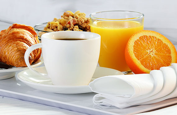 Eggs, croissant and orange juice on a tray