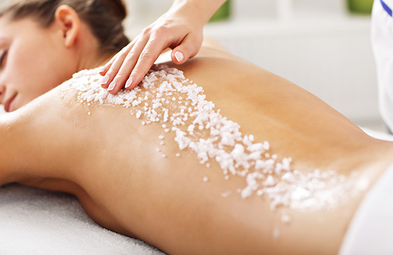 woman getting a scrub applied to her back