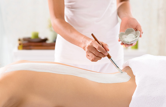 Spa technician applying body masque