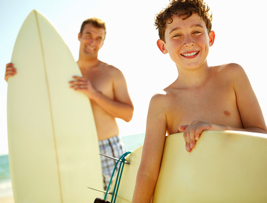 Father and Son heading out to surf on Pacific Beach