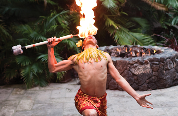 Polynesian dancer blowing fire at the Catamaran Sunset Luau