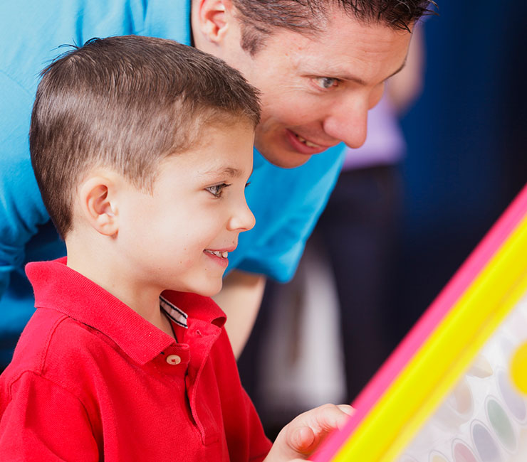 Young boy and dad enjoy playing video game