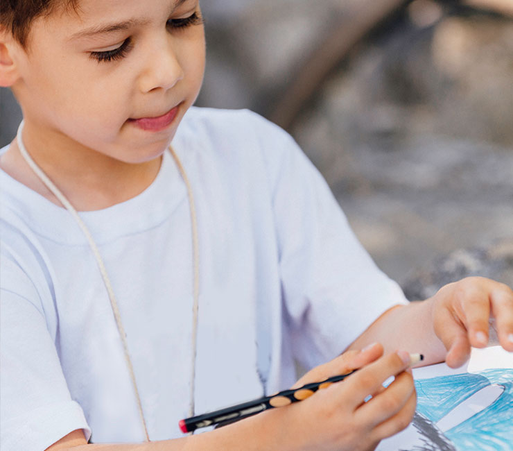 Young boy coloring a fish at the Kids Keiki Club at the Catamaran Resort Hotel, San Diego
