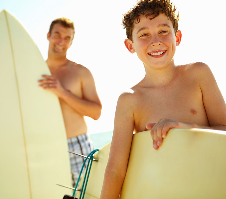 Father and Son heading out to surf on Pacific Beach