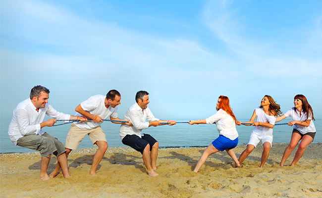 Friendly team-building beach game of tug of war at the Catamaran Resort Hotel and Spa