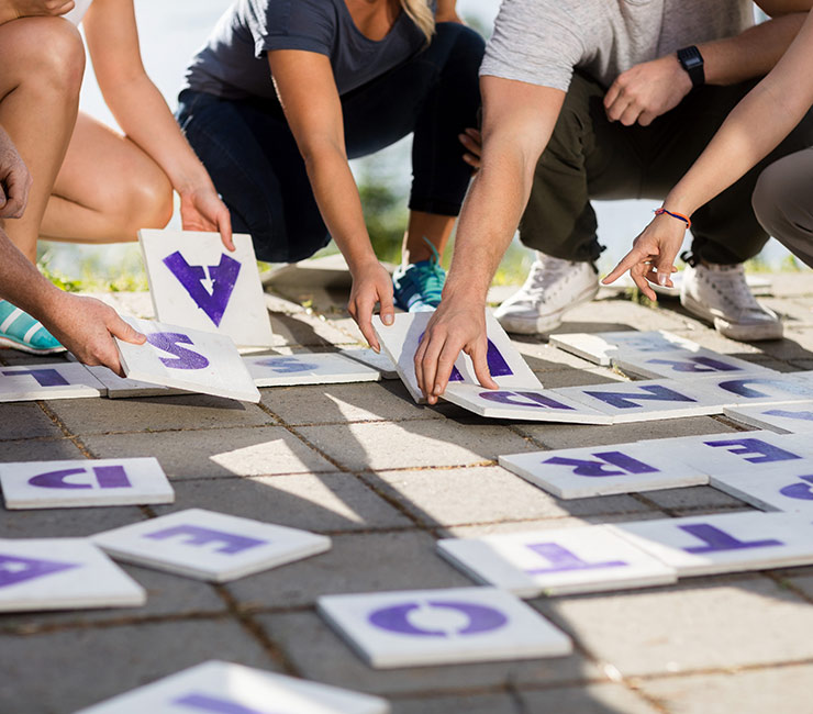 colleagues working together to solve a life size crossword puzzle at the Catamaran Resort Hotel in San Diego.