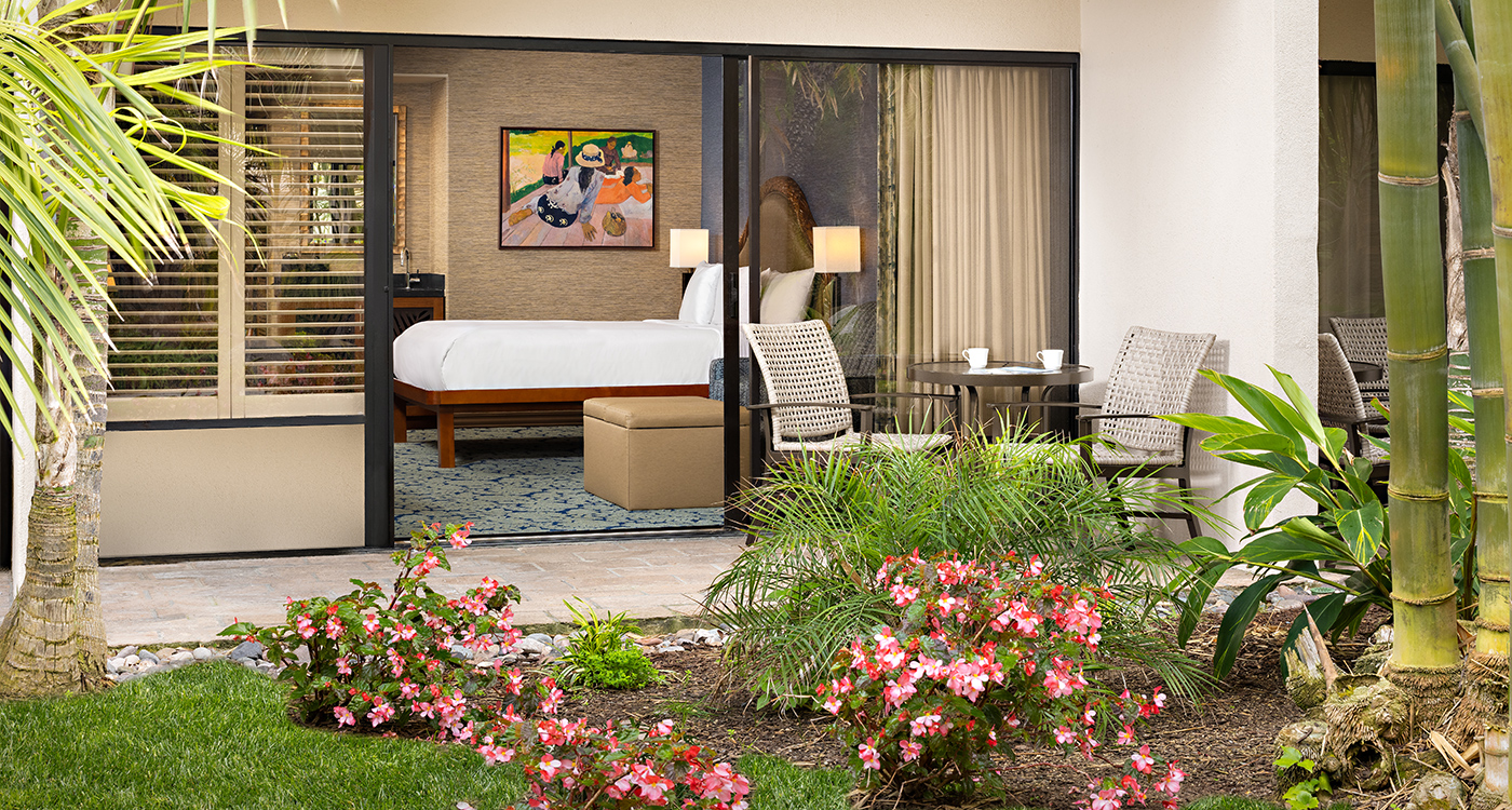 A garden view room with a bed, furniture, and plants
