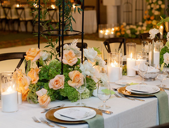 Wedding table with peach flowers and white candles for a reception at the Catamaran Resort