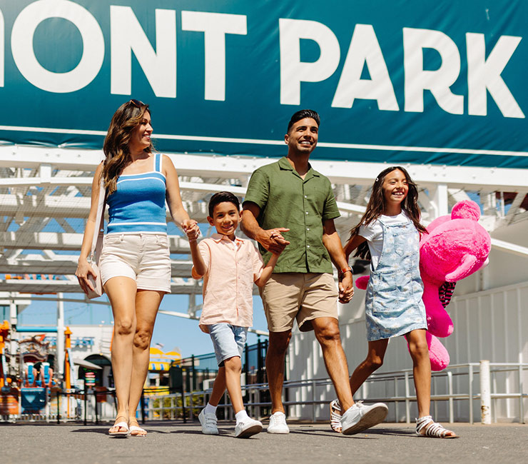 Family in front of wooden rollercoaster at Belmont Park