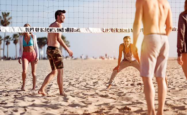 Group of people enjoying a game of volleyball at Pacific Beach