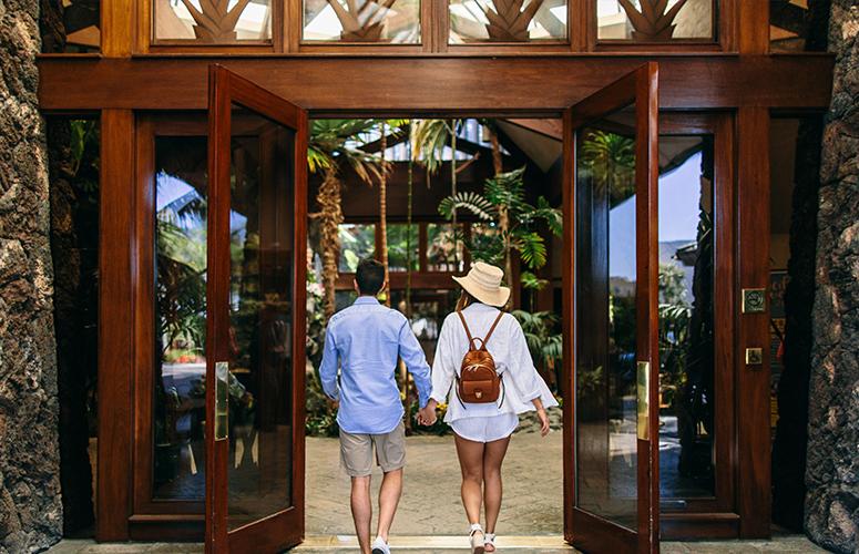 A couple walking through the open entrance doors of a building