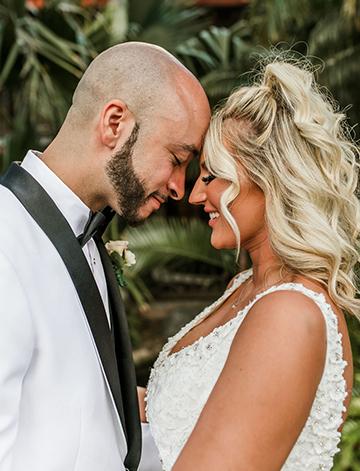 Jordan and Derrace, bride and groom touching foreheads and while sharing a moment at their wedding at the Catamaran Resort Hotel in San Diego.