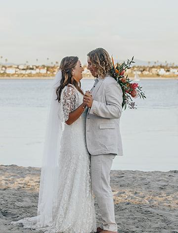 The bride and groom share a moment on their tropical wedding on shores of Mission Bay at the Catamaran Resort Hotel in San Diego.