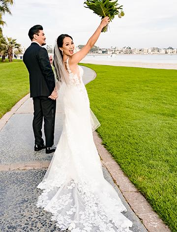 The bride in her elegant wedding dress looking back and acknowledging their guests after the couple weds at their classic wedding in San Diego.